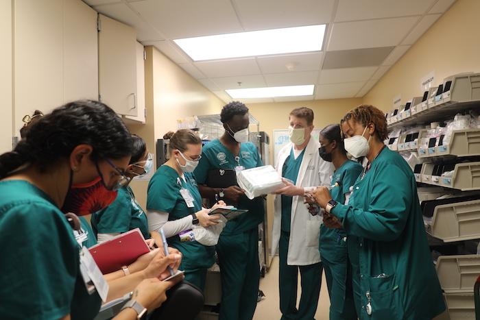 一位护理老师和一群学生在供应室里讲授医疗用品.